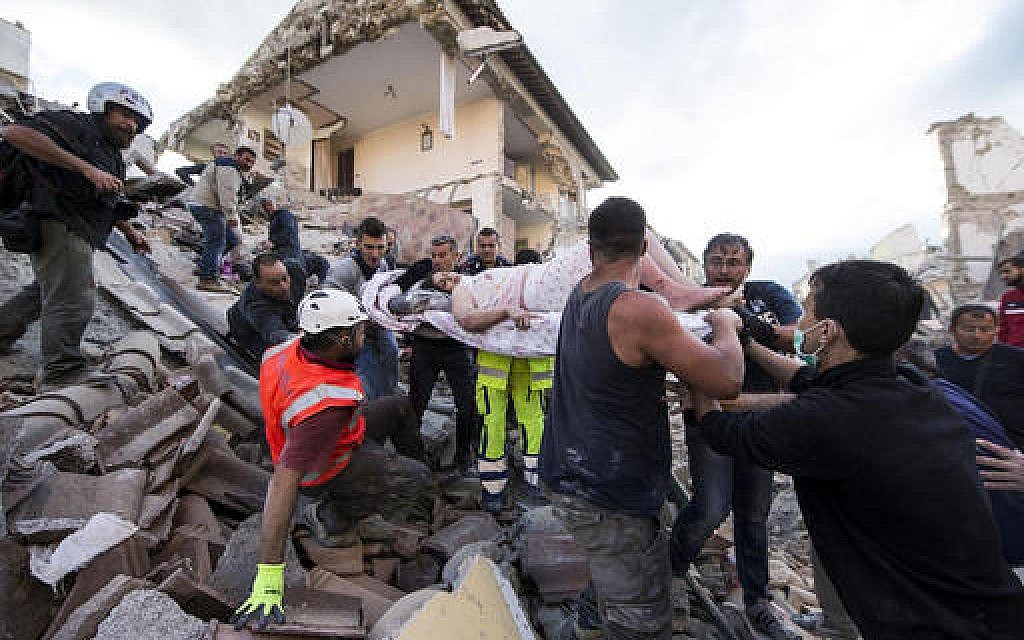 A woman is pulled out of the rubble following an earthquake in Amatrice, central Italy on Aug. 24, 2016. (Massimo Percossi/ANSA via AP)