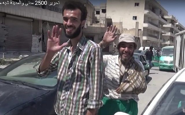 Syrian civilians wave as the town of Manjib is freed from IS control by US-backed coalition forces, August 12, 2016. (Screenshot/Anha)