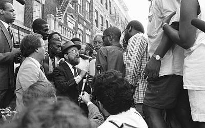 New York City Mayor David Dinkins, fourth from right, looking on while a Hasidic Jew and a black man argue during riots in Crown Heights, Brooklyn, in 1991. (Anthony Pescatore/NY Daily News Archive via Getty Images/via JTA)