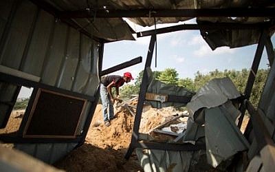 A Palestinian man inspects the rubble of a makeshift dwelling on August 22, 2016 in Beit Lahia in the northern Gaza Strip, following an Israeli airstrike the day before that targeted Hamas positions in the Gaza Strip in response to a rocket fired from the Palestinian enclave hits the Israeli city of Sderot. AFP / Mahmud Hams