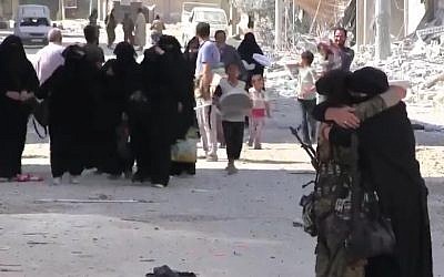 A Syrian woman hugs a Syrian Democratic Forces fighter after the coalition force freed the town on Manbij from IS control, August 13 2016. (Screenshot/K24)