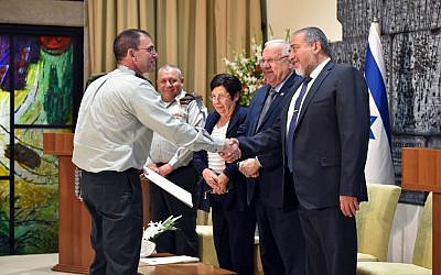 Maj. Gen. Doron Piles (left) shakes hands with Defense Minister Avigdor Liberman as he receives his appointment as the new president of the IDF's Military Court of Appeals, during a ceremony at the President's Residence attended by President Reuven Rivlin, President of the Supreme Court Miriam Naor and IDF Chief of Staff Gadi Eisenkot on August 15, 2016. (Ariel Hermoni/Defense Ministry)