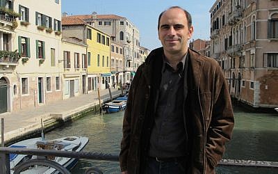 Illustrative: Shaul Bassi, coordinator of the Venice Ghetto 500 anniversary committee, on the Ghetto Nuovo bridge in Venice, Italy, July 2016. (Ruth Ellen Gruber)