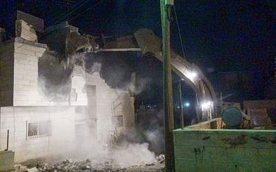 An Israeli excavator demolishes the top floor of the building where Muhammad Muhamra, a terrorist who carried out a deadly shooting attack in Tel Aviv's Sarona Market, lived on August 4, 2016. (IDF Spokesperson's Unit)