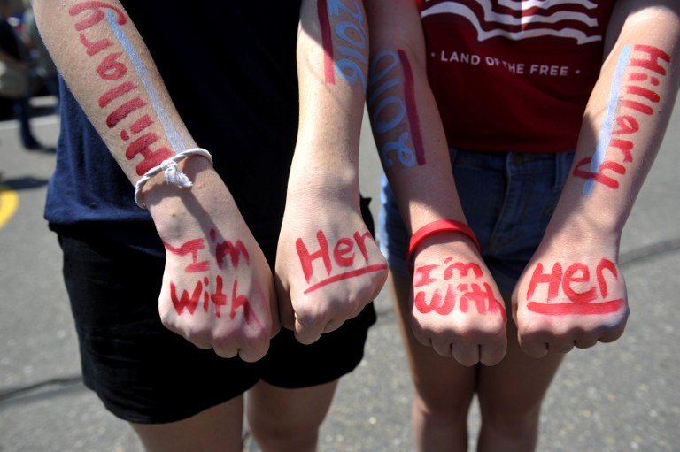 Two young supporters of Democratic presidential nominee Hillary Clinton painted their faces in anticipation of Clinton's speech at Adams City High School in Commerce City, Colorado on August 3, 2016. (AFP PHOTO / Jason Connolly)