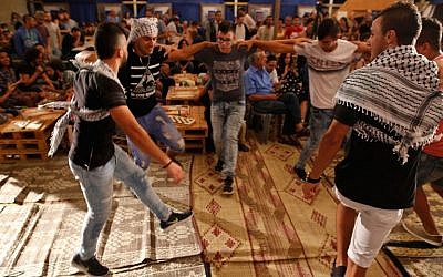 Palestinian men perform a traditional dance during a backgammon tournament between Palestinians and Israelis in Jerusalem on August 31, 2016. (AFP PHOTO / GIL COHEN-MAGEN).