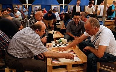 Israeli Arab Abu Riad (L) plays against Israeli David Aviv (R) during a backgammon tournament between Palestinians and Israelis in Jerusalem on August 31, 2016. (AFP PHOTO / GIL COHEN-MAGEN).