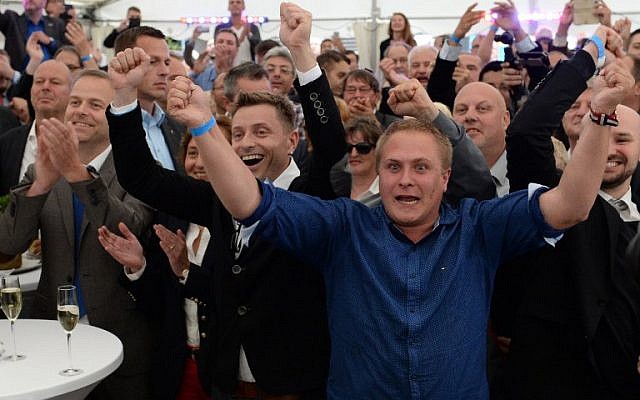 Supporters of the anti-migrant populist AfD party react as exit polls are announced on TV during an election results party on September 4, 2016 in Schwerin, north-eastern Germany. (AFP Photo/dpa/Daniel Bockwoldt)