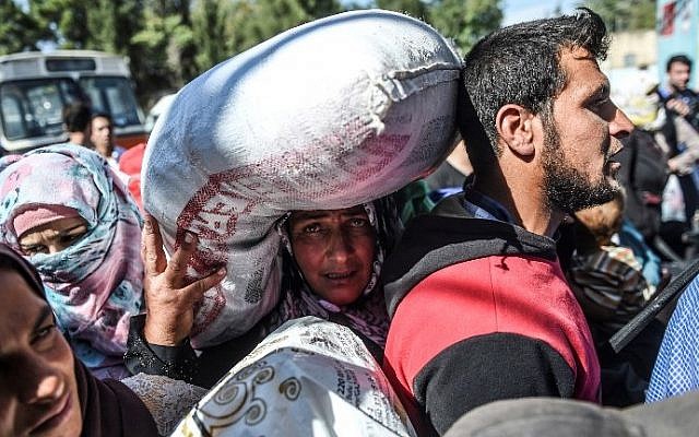 Syrian refugees walk on their way back to the Syrian city of Jarabulus on September 7, 2016 at Karkamis crossing gate, in the southern region of Kilis. (AFP PHOTO / BULENT KILIC) Syrian refugees walk on their way back to the Syrian city of Jarabulus on September 7, 2016 at Karkamis crossing gate, in the southern region of Kilis. (AFP PHOTO / BULENT KILIC)