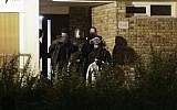 A handcuffed man is taken out of a building in Boussy-Saint-Antoine, south of Paris, on September 8, 2016 where female suspects, said to have been planning new acts of violence, were arrested. (AFP/Geoffroy Van Der Hasselt)