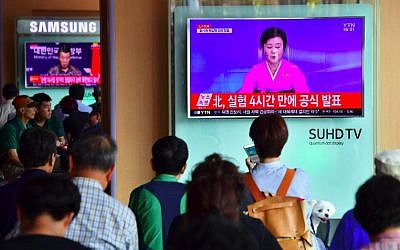 People watch a television news broadcast showing a North Korean anchor announcing the country's latest nuclear test, at a railway station in Seoul on September 9, 2016. (AFP  Jung Yeon-Je)