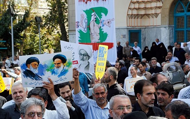 Iranians hold portraits of Iran's Supreme Leader Khamenei (L), Bahraini Shiite cleric Sheikh Isa Qassim (C) and the founder of the Islamic republic Ayatollah Khomeini (R) during an anti-Saudi demonstration in Tehran on September 9, 2016. (AFP PHOTO/STR)