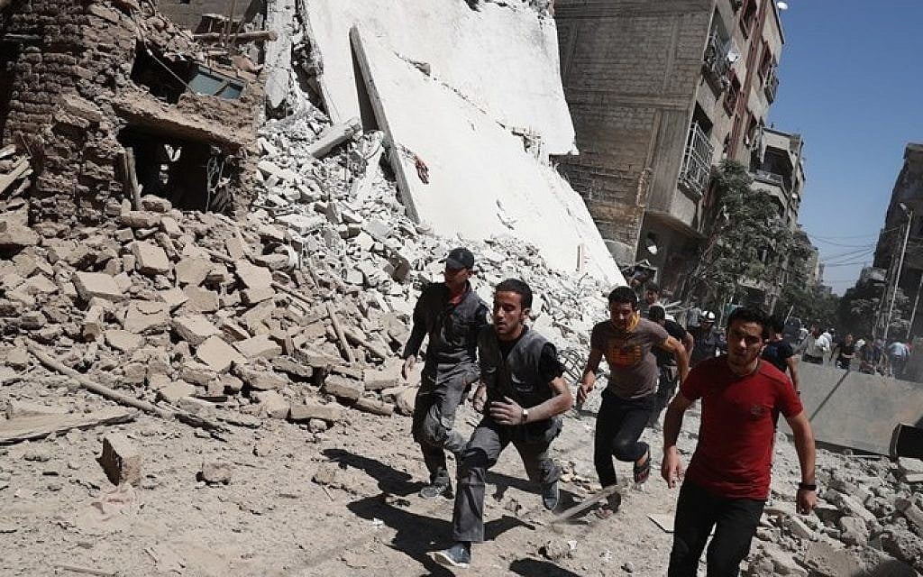 Syrians run for cover during reported government air strikes in the rebel-held town of Douma, east of the capital Damascus, on September 9, 2016. (Abd Doumany / AFP)