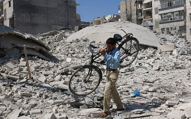 A Syrian man carrying a bicycle makes his way through the rubble of destroyed buildings following a reported air strike on the rebel-held Salihin neighbourhood of the northern city of Aleppo, on September 11, 2016. (AFP PHOTO / AMEER ALHALBI)