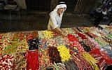 A Palestinian man buys sweets as Muslims shop in preparation for the holiday of Eid al-Adha at the market in the Old City of Jerusalem on September 11, 2016. (AFP PHOTO/HAZEM BADER)