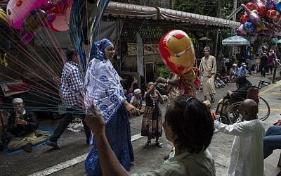Thai and foreign Muslims mingle on the street on the day of Eid al-Adha celebrations at Haroon Mosque in Bangkok on September 12, 2016.(AFP PHOTO / LILLIAN SUWANRUMPHA)