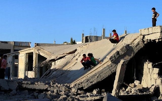 Syrian children slide down rubble of destroyed a building in the rebel-held city of Daraa, in southwestern Syria on September 12, 2016 (AFP PHOTO / MOHAMAD ABAZEED)