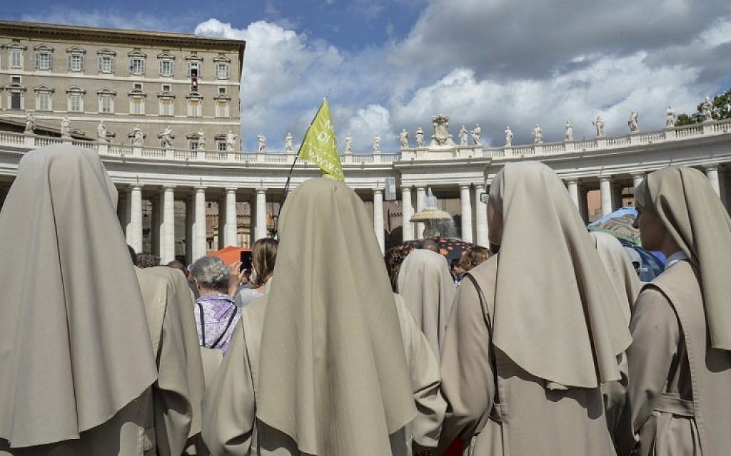 Nuns look at Pope Francisas waving to the crowd from the window of the apostolic palace overlooking St Peter's square during his Angelus prayer, in the Vatican City, on September  18, 2016. (AFP/ ANDREAS SOLARO)