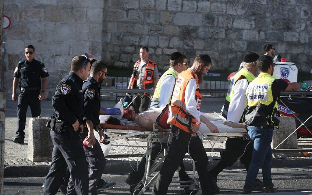 Israeli medics carry an injured man following a Palestinian stabbing attack outside the Old City of Jerusalem, on September 19, 2016 (AFP PHOTO / MENAHEM KAHANA)