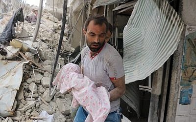 A Syrian man carries the body of an infant retrieved from under the rubble of a building following a reported airstrike on September 23, 2016, on the al-Muasalat area in the northern Syrian city of Aleppo. (AFP PHOTO/THAER MOHAMMED)