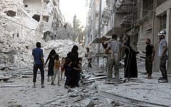 A Syrian family leaves the area following a reported airstrike on September 23, 2016, on the al-Muasalat area in the northern city of Aleppo. (AFP/Thaer Mohammed)