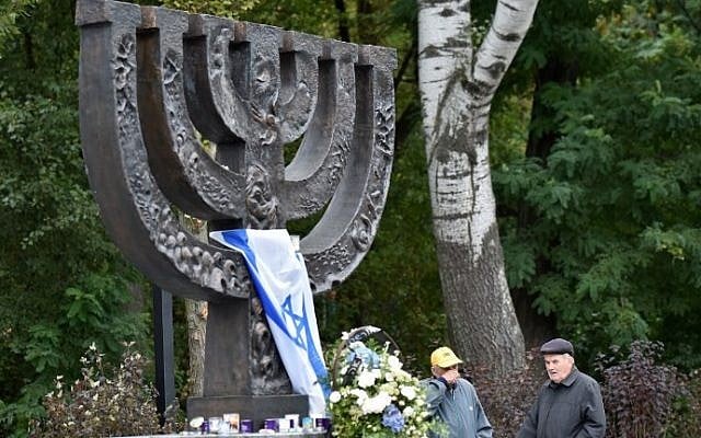 Men react during a visit to the Babi Yar menorah monument in Kiev on September 23, 2016. (AFP Photo/ Sergei Supinsky)