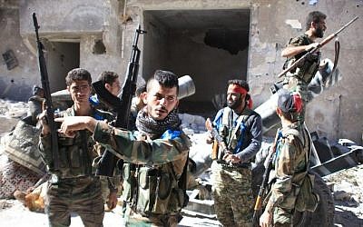 Syrian government forces gather in the largely deserted Palestinian refugee camp of Handarat, north of Aleppo, on September 24, 2016 after they captured the area following multiple Russian air strikes. (AFP PHOTO / GEORGE OURFALIAN)