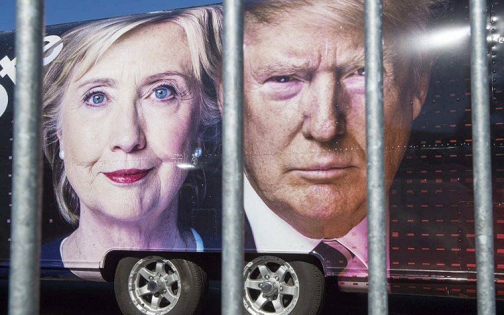 Large images of Democratic nominee Hillary Clinton and Republican nominee Donald Trump are seen on a CNN vehicle, behind a security fence, on September 24, 2014, at Hofstra University, in Hempsted, New York. (AFP/ PAUL J. RICHARDS)