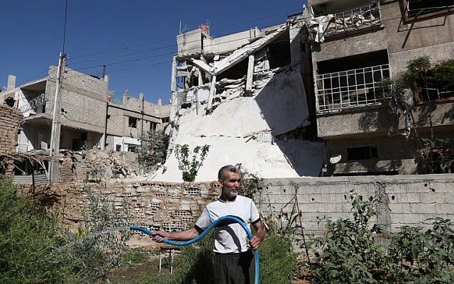 A Syrian man waters his plants in the rebel-held town of Douma, on the eastern outskirts of the capital Damascus on September 25, 2016. (AFP/Abd Doumany)