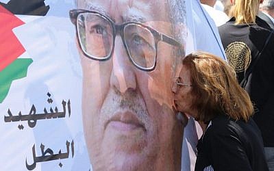 A protester kisses a portrait of prominent Jordanian writer Nahed Hattar, who was shot dead the previous day outside an Amman court, during a demonstration in front of the prime minister's offices on September 26, 2016. (AFP PHOTO / Khalil MAZRAAWI)