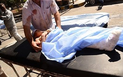 A wounded Syrian child is rushed into a hospital after she was hit by mortar shells that targeted Aleppo's government controlled Aziziyah and Suleimaniyah neighbourhoods on September 28, 2016. (AFP/GEORGES OURFALIAN)