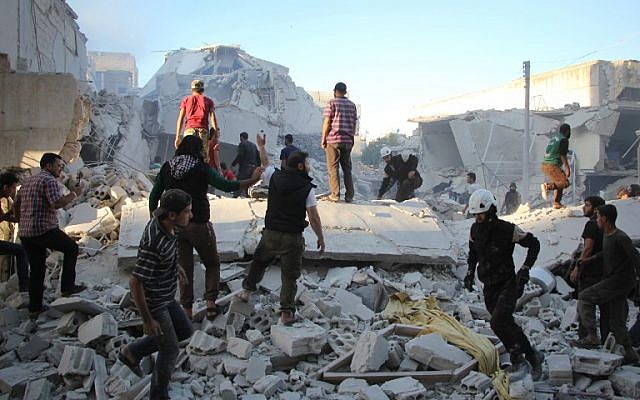 Syrian men search for people under the rubble of destroyed buildings following a reported air strike on the rebel-held northwestern city of Idlib on September 29, 2016. (AFP PHOTO / Omar haj kadour).