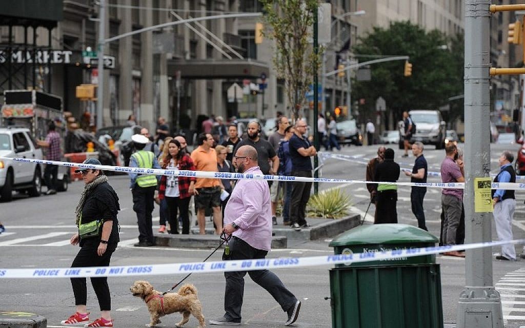 People walk outside of a barricaded zone following an explosion on 23rd St. in Manhattan's Chelsea neighborhood on September 18, 2016 in New York City.  (Stephanie Keith/Getty Images/AFP)