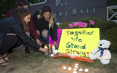 Ariel Pantoja (L), 19, Bayley Morrow (C), 18 and Makayla Bentley (R), 18, light candles at a makeshift memorial outside the Cascade Mall on September 24, 2016 in Burlington, Washington. (Karen Ducey/Getty Images/AFP)