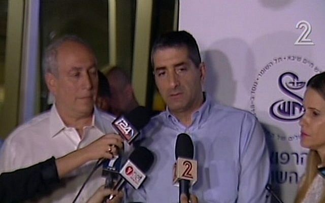 Chemi Peres (L) the son of Shimon Peres, and Dr. Yitzhak Kreiss, talk to reporters at Sheba Medical Center in Tel Hashomer on September 13, 2106, after former president Peres was hospitalized there having suffered a stroke. (screen capture: Channel 2)