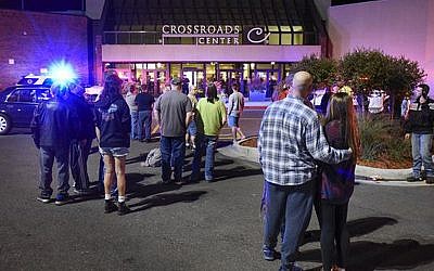 People stand near the entrance on the north side of Crossroads Center mall between Macy's and Target as officials investigate a reported multiple stabbing incident, Saturday, September 17, 2016, in St. Cloud, Minnesota. (Dave Schwarz/St. Cloud Times via AP)