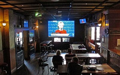 People watch the the US presidential debate between Democrat presidential nominee Hillary Clinton and Republican presidential nominee Donald Trump televised live at King O'Malley's Irish Pub in Canberra, Australia, September 27, 2016. (AP Photo/Rod McGuirk)