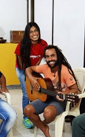 Musician Lior ben Hur playing guitar with members of the Barranquilla community. (Courtesy)