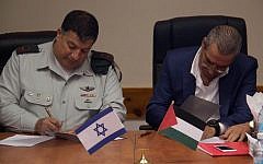 COGAT’s Major General Yoav (Poly) Mordechai and the Palestinian Authority’s Minister of Civil Affairs, Hussein al-Sheik sign a Memorandum of Understanding to upgrade the postal service system in Judea and Samaria, September 4, 2016 (COGAT)
