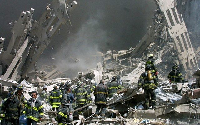 In this Sept. 11, 2001 file photo, firefighters make their way through the rubble after two airliners flown by Al-Qaeda terrorists crashed into the World Trade Center in New York bringing down the landmark buildings. (AP Photo/Shawn Baldwin/File)