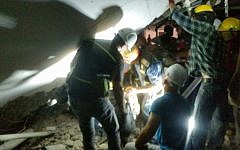 Rescue workers attempt to evacuate people from a collapsed parking structure in the Ramat Hahayal neighborhood in northern Tel Aviv, September 5, 2016. (Israel Fire and Rescue Services)