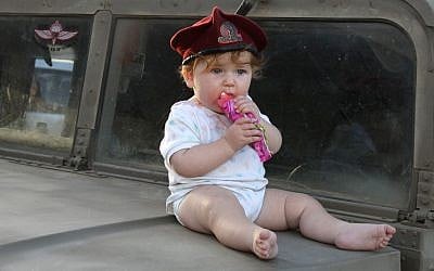 A baby wearing a beret on an IDF jeep on June 29, 2014. (Gershon Elinson/FLASH90)