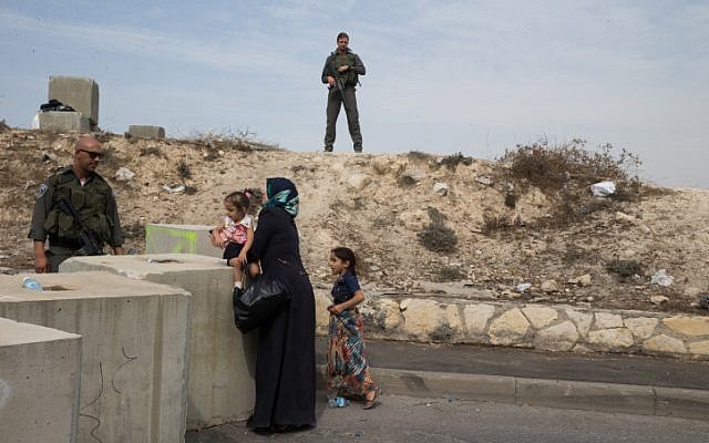 Israeli Border Police block the entrance to the East Jerusalem neighborhood of Issawiya, checking Palestinians wanting to pass, on October 20, 2015. Following the recent wave of terror attacks in Jerusalem and Israel, Israel Police is blocking East Jerusalem neighborhoods checking for knives and anything that can be used as a weapon. (Nati Shohat/Flash90)