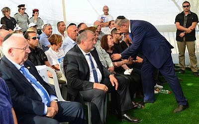 Prime Minister Benjamin Netanyahu speaks with Zehava Shaul during the funeral of her husband Herzl Shaul at the Poria Illit cemetery in Northern Israel, September 4, 2016 (Kobi Gideon/GPO)
