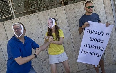 Activists, including two with masks of Benjamin Netanyahu and Yisrael Katz, protest against the decision to cancel all infrastructure work planned by Israel Railways on Shabbat on September 4, 2016. Yonatan Sindel/Flash90)