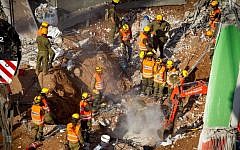 Search and rescue workers remove a third body from the rubble of a collapsed parking garage in Tel Aviv on September 6, 2016. (Miriam Alster/Flash90)