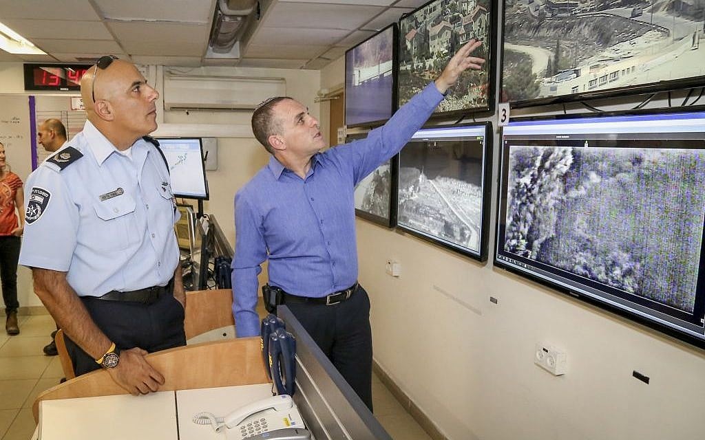 Efrat municipality head Oded Revivi, right, and police commander Moshe Barkat look at security footage in following a stabbing attack in Efrat on September 18, 2016. (Gershon Elinson/Flash90)