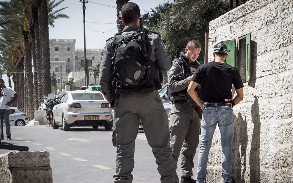 An Israeli border police officer searches a Palestinian man in front of Damascus Gate in Jerusalem's Old City, September 20, 2016. (Sebi Berens/Flash90)
