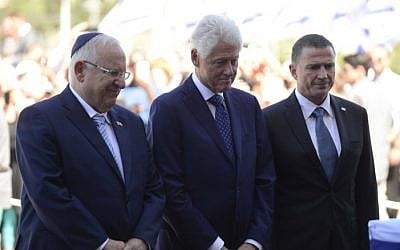 Former US president Bill Clinton pays his respects by the coffin of former president Shimon Peres ahead of the ceremony held at the Knesset plaza, where the public will be invited to pay their last respects before his burial, in Jerusalem, on September 29, 2016. (Tomer Neuberg/Flash90)