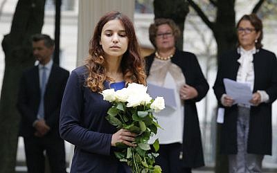 An unidentified relative of victims is to lay flowers during a ceremony for victims of terrorism in Paris, Monday Sept.19, 2016. (AP Photo/Michel Euler, Pool)
